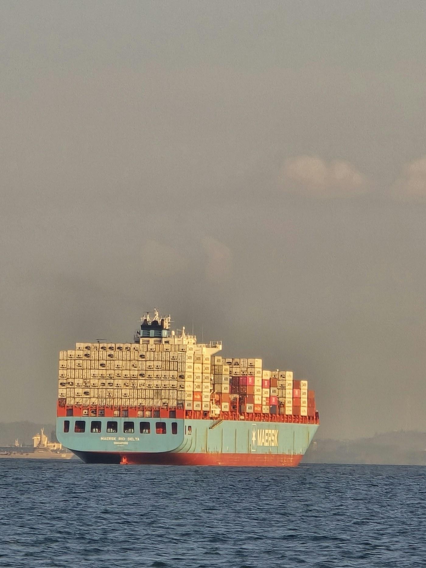 Containerschiff auf offener See bei Sonnenuntergang