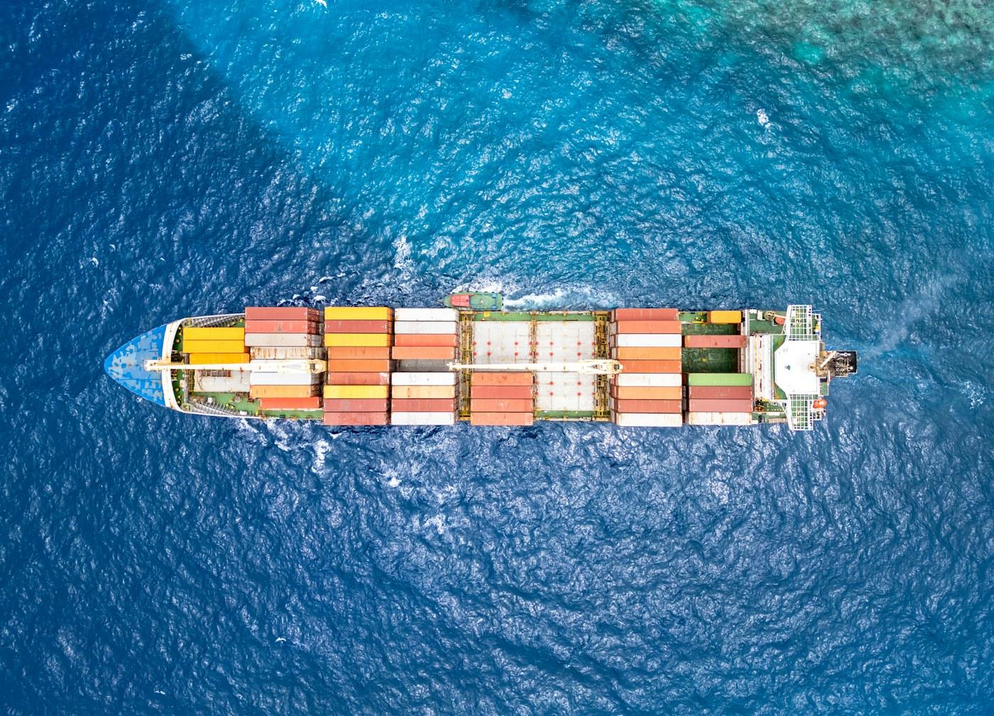 Luftaufnahme eines großen Containerschiffs auf See als Symbol für globale Schifffahrtsrouten unter geopolitischem Druck